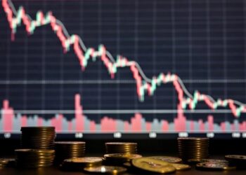 monedas de bitcoin y gráficos de precio en caída rojos