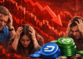 Personas tomándose la cabeza delante de gráficos de precios en rojo y una pila de monedas físicas de dash y decred.