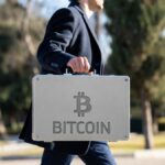 Persona con maletรญn que tiene grabado el logo de bitcoin.