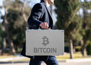 Persona con maletín que tiene grabado el logo de bitcoin.