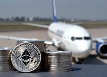 Monedas físicas de Ethereum delante de un avión boeing 737.