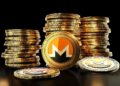 Una moneda física de monero delante de pilas de monedas