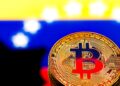 Moneda física de Bitcoin sobre bandera de Venezuela, adopción de criptomonedas en el país, uso de BTC como refugio ante inflación venezolana.