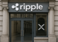Fachada de una oficina de banco con los logos de Ripple y de XRP.