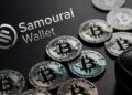 Monedas físicas de bitcoin rodean un monedero con el logo de Samourai walet