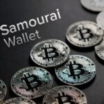 Monedas físicas de bitcoin rodean un monedero con el logo de Samourai walet