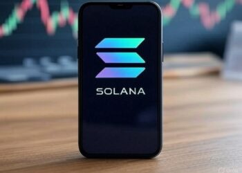 Smartphone sobre mesa de madera mostrando el logo de Solana en pantalla.