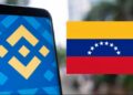 Teléfono inteligente que refleja el logo de Binance junto a una bandera de Venezuela.