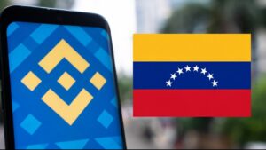 Teléfono inteligente que refleja el logo de Binance junto a una bandera de Venezuela.