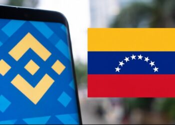 Teléfono inteligente que refleja el logo de Binance junto a una bandera de Venezuela.