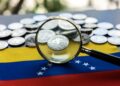 Monedas USDT y detrรกs la bandera de Venezuela y una lupa observando.