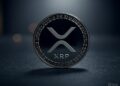 Una moneda física de XRP delante de un fondo gris.