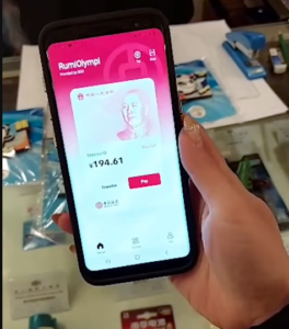 Una mano femenina sostiene un telรฉfono en el que se ve la app del yuan digital.