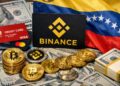 Monedas físicas de bitcoin, criptomonedas, con el logo de Binance, tarjetas bancarias y la bandera de Venezuela, así como dólares.