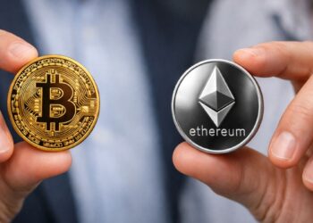 Una persona sosteniendo una moneda física de bitcoin y otra de Ethereum en primer plano.