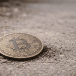Una moneda física de bitcoin en el suelo.