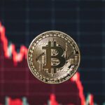 moneda de bitcoin y grรกfico de precio en caรญda rojo.