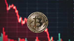 moneda de bitcoin y gráfico de precio en caída rojo.