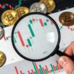 Lupa sobre gráfico de bitcoin y monedas BTC.