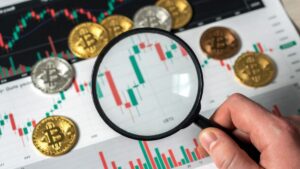 Lupa sobre gráfico de bitcoin y monedas BTC.