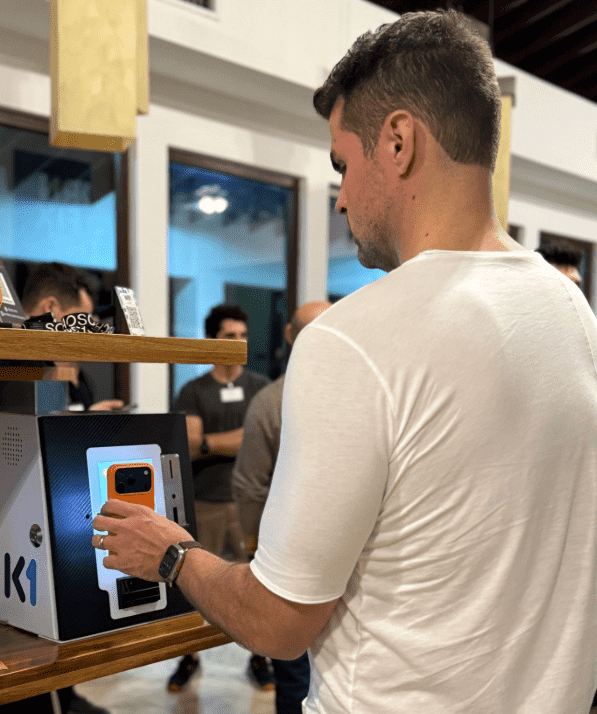 Una persona coloca su teléfono para escanear la pantalla de un cajero K1 mini desarrollado en El Salvador para comprar bitcoin.