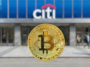 Una moneda fรญsica de Bitcoin dorada en primer plano con el logotipo de un banco Citi desenfocado al fondo