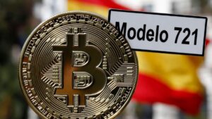 Moneda física de bitcoin dorada con un cartel que dice "Modelo 721" y la bandera de España detrás.