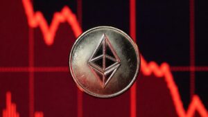 Moneda de Ethereum y gráfico de precio en caída rojo.