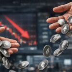 Manos dejando caer monedas fรญsicas de Ethereum frente a una pantalla bursรกtil con grรกfico rojo en caรญda.