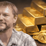 Fotografía de Nick Szabo en primer plano. En el fondo: lingotes de oro y monedas físicas de bitcoin.