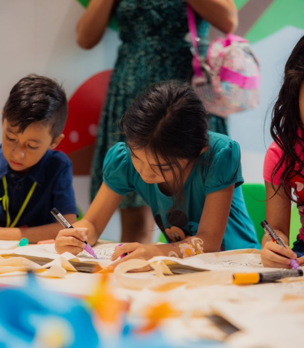 Fotografía a niños en un salón de clases escribiendo.