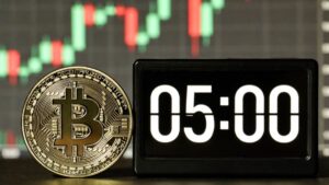 Bitcoin físico dorado junto a un cronómetro de 5 minutos sobre fondo de gráfico de precios.