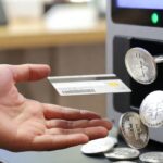 Una mano presentando una tarjeta sobre un cajero automático, del cual brotan monedas de USDT. Fuente: Imagen generada por Grok.