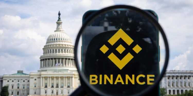 Fotografรญa del Senado de EE. UU. con un telรฉfono que muestra el logo de Binance, con una lupa sobre el logo.
