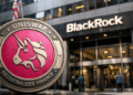 En primer plano: moneda física con el logo de Uniswap. En el fondo: edificio corporativo de BlackRcok.
