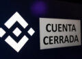 Teléfono inteligente que refleja el logo de Binance y un anuncio que dice "cuenta cerrada".