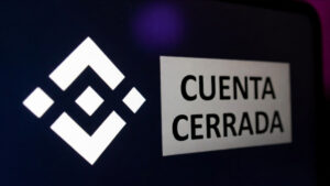 Telรฉfono inteligente que refleja el logo de Binance y un anuncio que dice "cuenta cerrada".