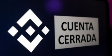 Teléfono inteligente que refleja el logo de Binance y un anuncio que dice "cuenta cerrada".