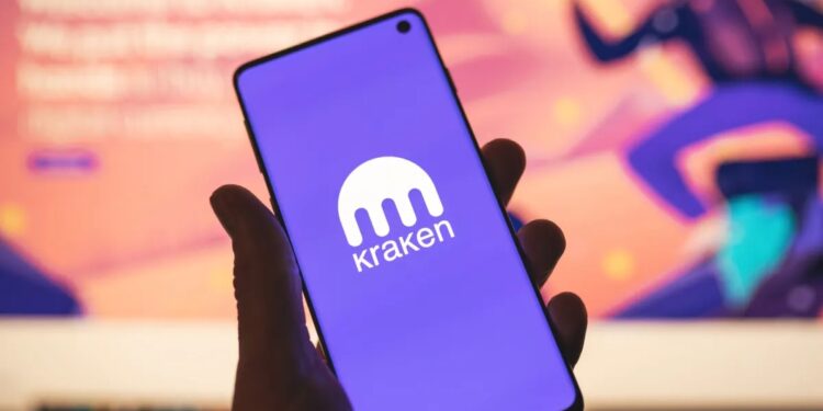 Persona sujetando un teléfono inteligente que muestra el logo de Kraken.
