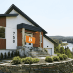 Una vivienda sobre una colina con una bandera naranja con el logo de Bitcoin.