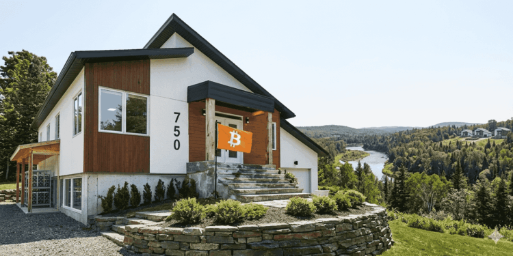 Una vivienda sobre una colina con una bandera naranja con el logo de Bitcoin.