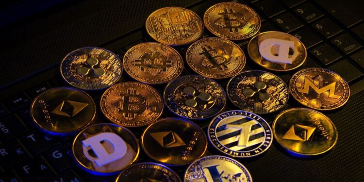 Muchas monedas físicas doradas sobre una mesa.