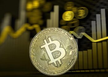 Moneda de bitcoin sobre un grafico financiero