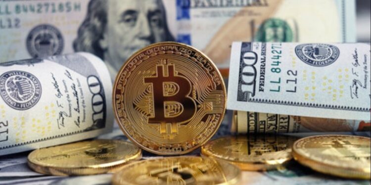 Moneda física de bitcoin dorada rodeada de billetes de 100 dólares estadounidenses.