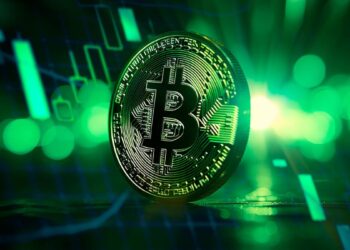 Moneda física de bitcoin dorada con un fondo de gráfico de precio donde el color verde predomina.