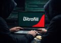 Computadora reflejando el logo de Bitrefill, la PC siendo manejada por hackers encapuchados, y criptomonedas en el escritorio.