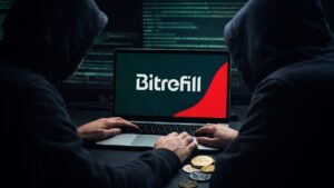 Computadora reflejando el logo de Bitrefill, la PC siendo manejada por hackers encapuchados, y criptomonedas en el escritorio.