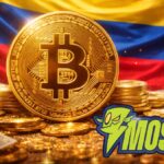 Moneda fรญsica de bitcoin, con la bandera de Colombia en el fondo y el logo de Mostro.