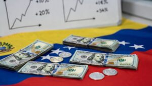 Dólares en una mesa con la bandera de Venezuela, con algunas monedas de USDT, y un pizarrón de gráficas alcistas.