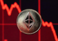Moneda de Ethereum y gráfico de precio en caída rojo.